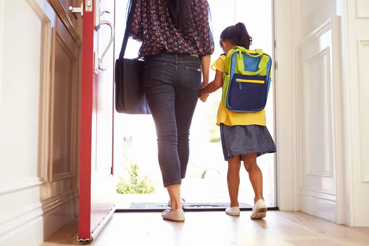 fm=f_5zNONO0 A woman and child walking in front of a door.