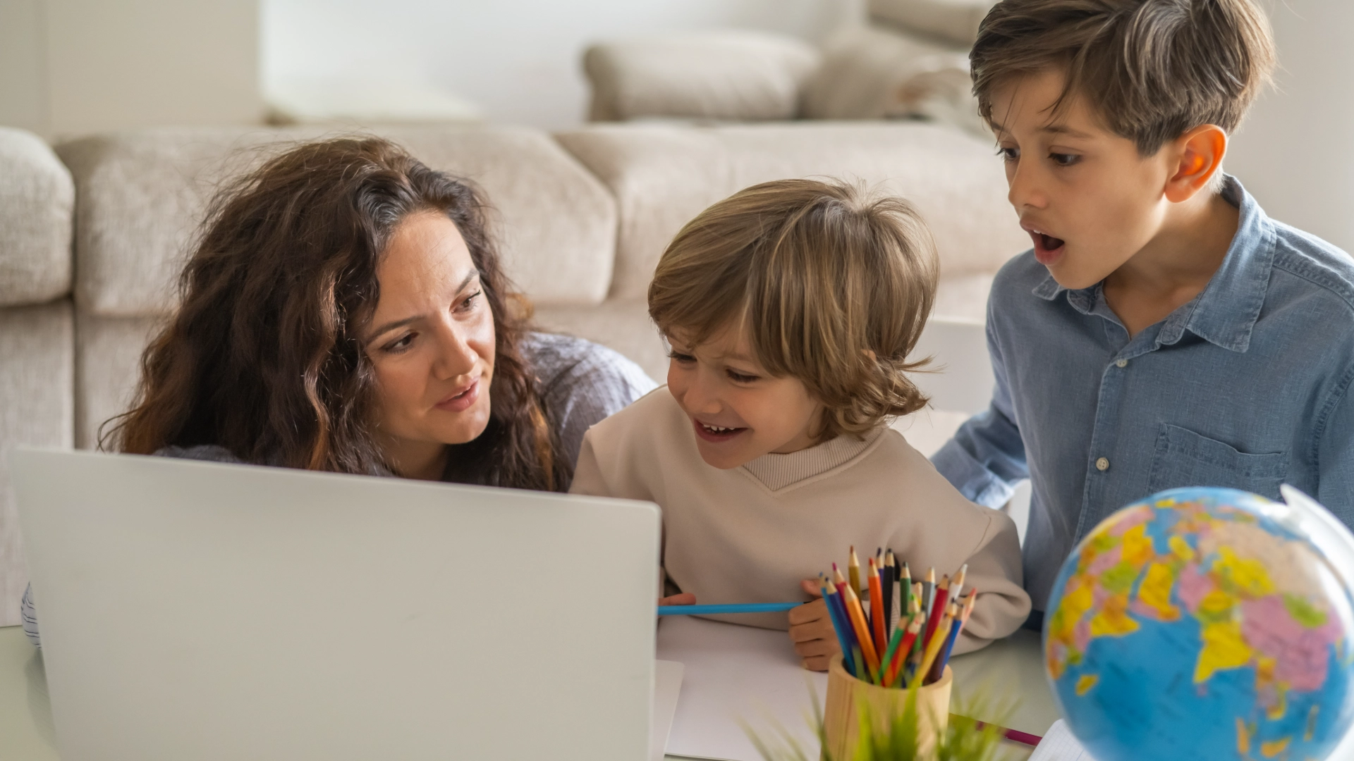 GettyImages-2203739006_12_11zon Family learning together with laptop and globe.