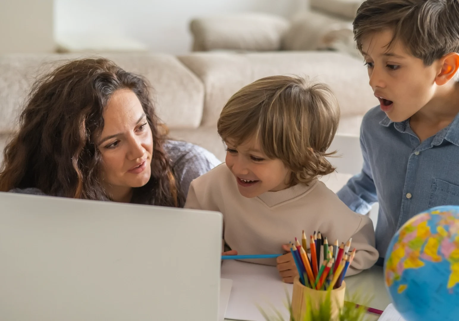 Family learning together with laptop and globe.